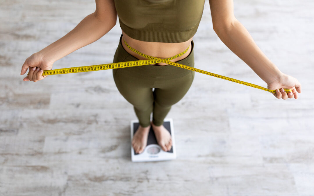 Woman standing on scale measuring waist representing weight maintenance after stopping a GLP-1 medication