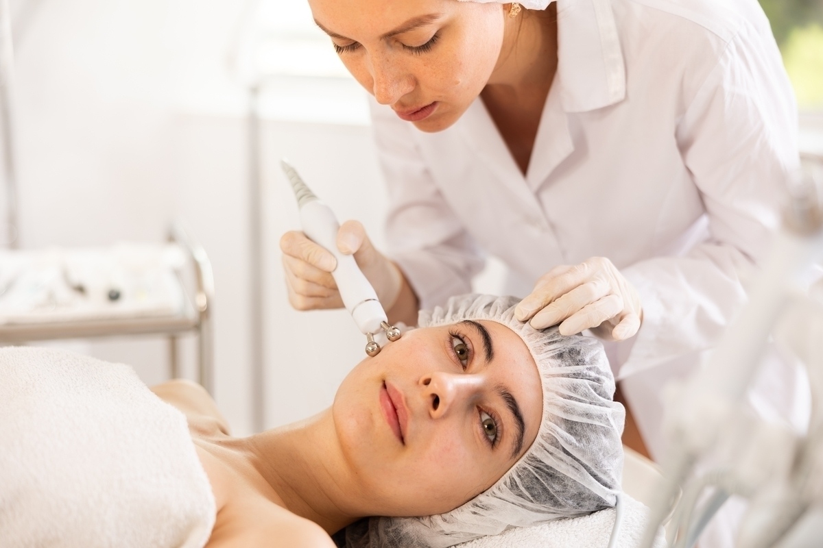 Provider using a handheld device on a patient's face showing what is XERF skin tightening during a clinical treatment session