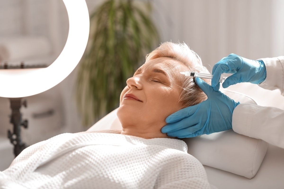 Mature woman receiving a forehead injection representing key Botox treatment areas at a medical aesthetics clinic
